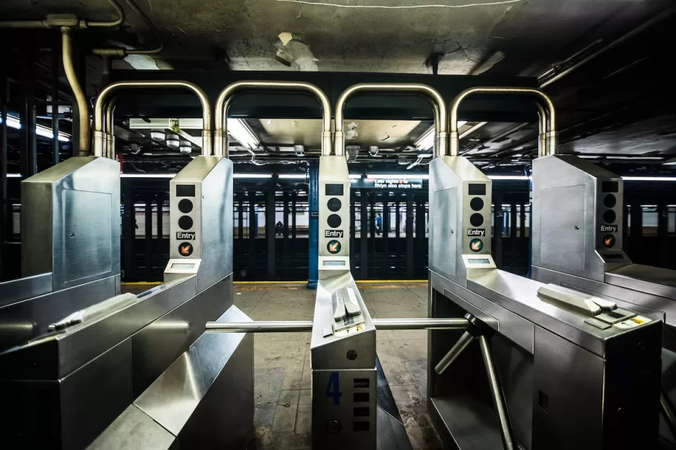Silver turnstiles at a subterranean subway station
